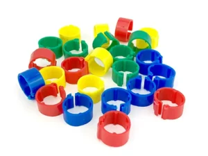 The image shows a collection of colorful plastic rings in red, blue, green, and yellow. They appear to be small and are likely used for organizing or marking purposes