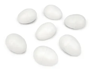 The image shows seven white plastic eggs arranged on a white background