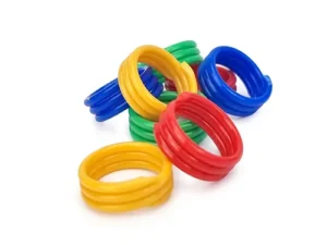A collection of colorful plastic rings in red, blue, yellow, and green, scattered on a white surface.