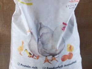 This is an image of a bag of poultry feed. The bag is labeled "KEWPIE" and mentions "50 years" and "Stockfeed King." It highlights that the feed is "Protein rich" and "Feedsafe® Accredited." The product is "Poultry Breeder Mash + M/plt" and the net weight is 20 kg. The design includes illustrations of chickens and chicks