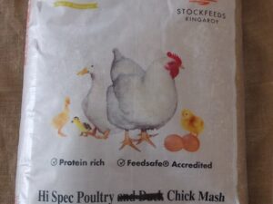 This is an image of a bag of Kewpie Stockfeeds. The bag features illustrations of a chicken, duck, and chicks, and it mentions "Hi Spec Poultry and Chick Mash." It highlights being "Protein rich" and "Feedsafe Accredited." The bag is marked as 20 kg NET.